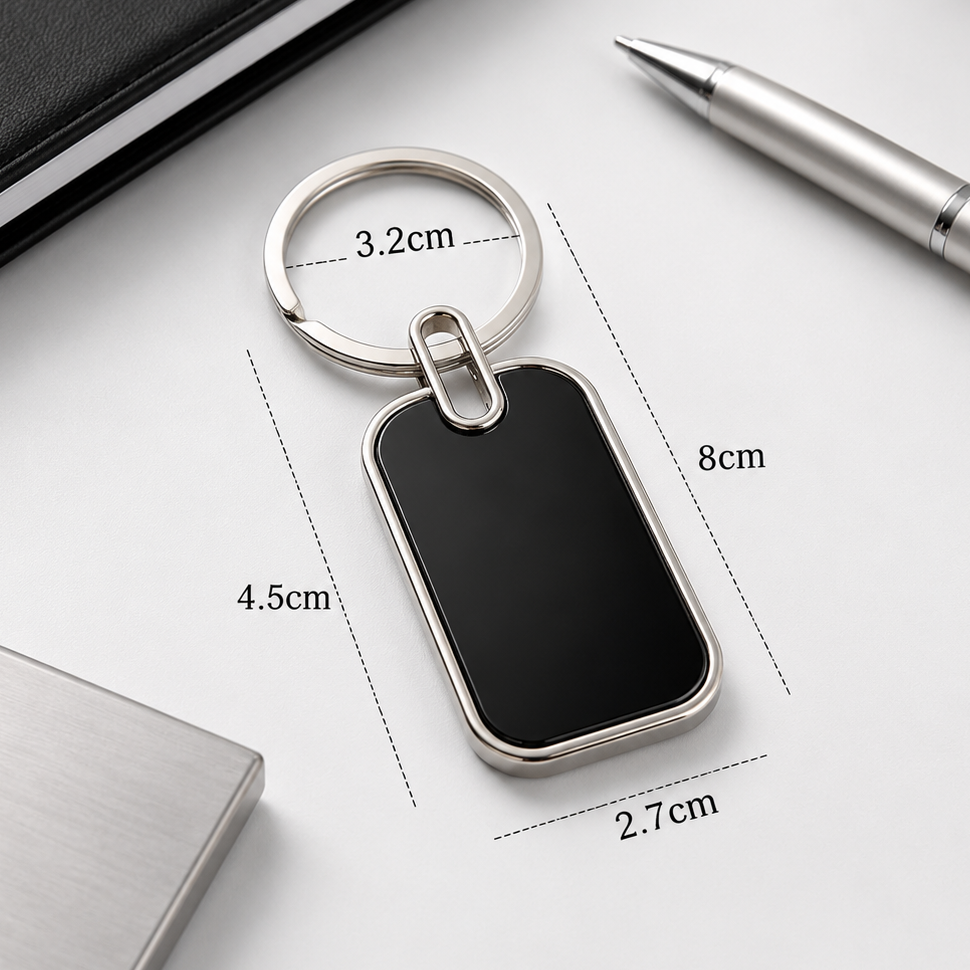Black keychain with measurements on a white surface with office items.